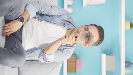 Vertical-video-of-Man-looking-at-camera-with-magnifying-glass.